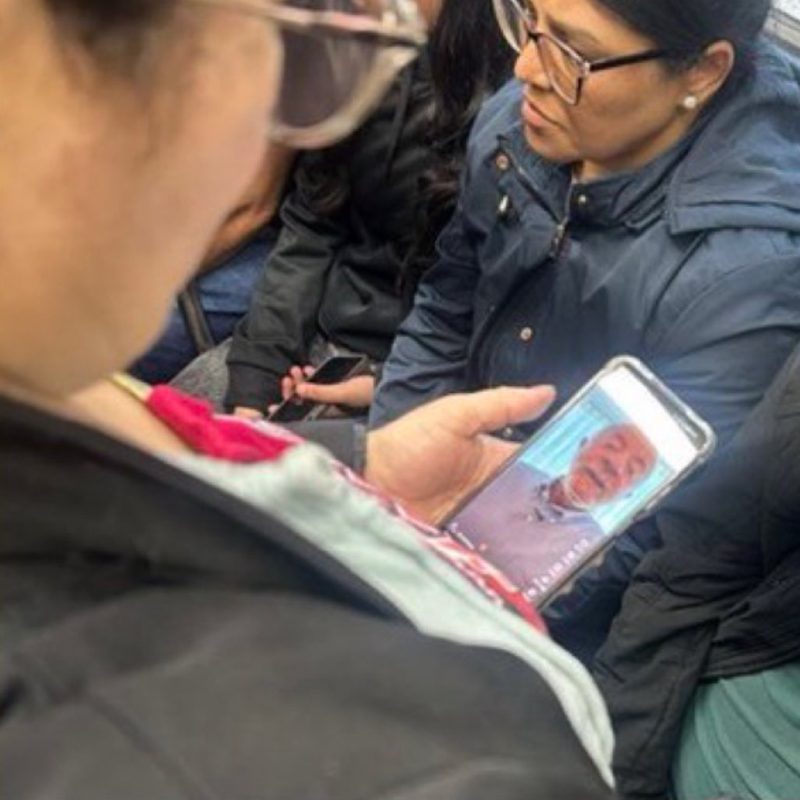 Passageira assistindo a um vídeo de um senhor no celular, no ônibus
