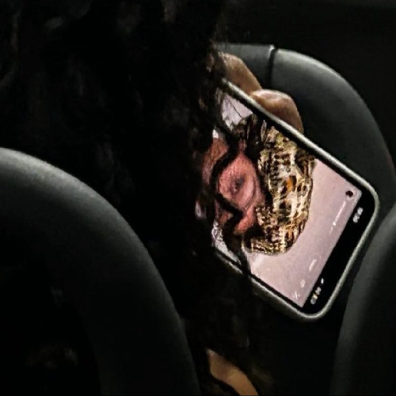Passageira com o celular na horizontal vendo um vídeo, no ônibus